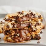 A stack of chocolate stuffed cookies, split in half to show the chocolate.