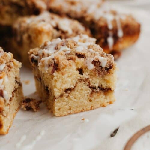 A close up of a slice of pecan sour cream coffee cake on parchment paper.