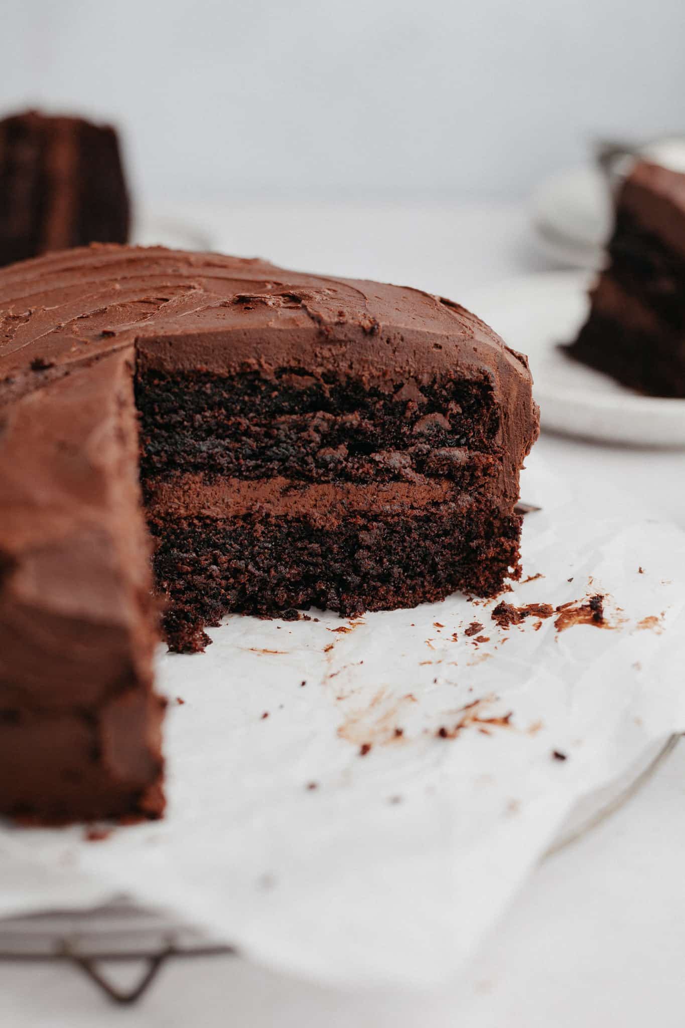 a two layer chocolate cake on parchment paper.