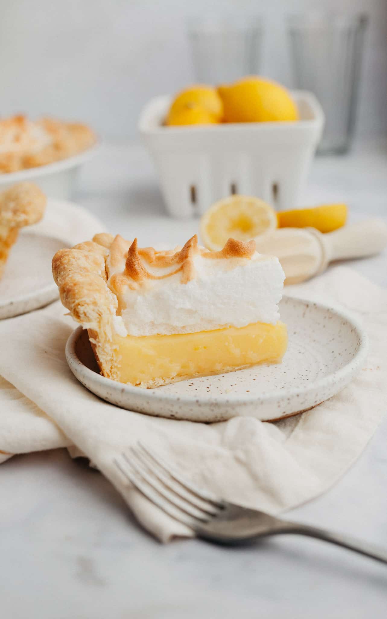 A slice of lemon meringue pie on a small white plate.