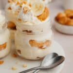 A close up of banana pudding in a jar on a marble surface.
