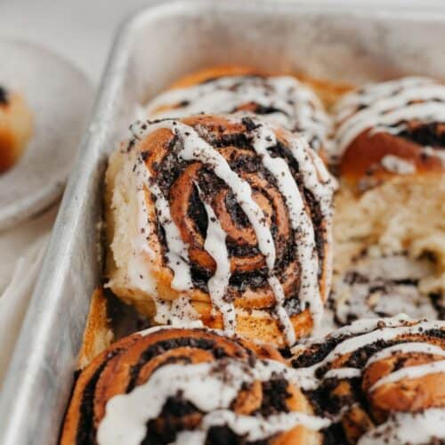 oreo cinnamon rolls drizzled with a white glaze, one cinnamon roll has been propped up.