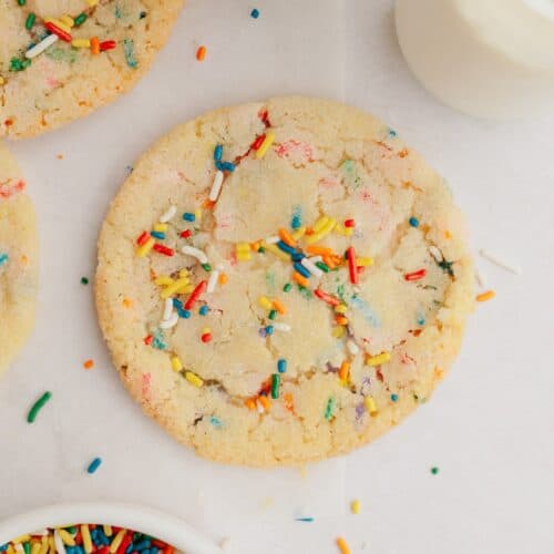 A sprinkle sugar cookies on parchment paper.