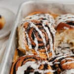 a close up of an oreo cinnamon rolls drizzled with a white glaze.