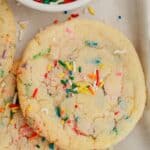 Several sprinkle confetti sugar cookies on parchment paper.