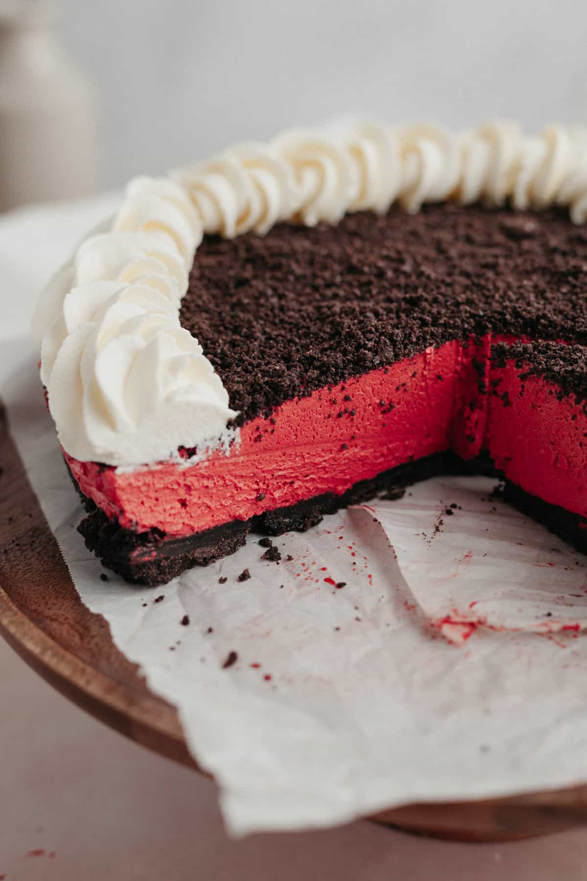 A close up of an Oreo red velvet cheesecake that has a few slices taken out of it.