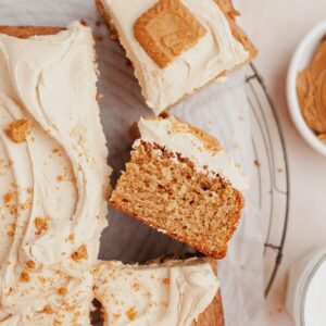 An overhead shot of a sheet cake covered in beige frosting and topped with Biscoff cookies.