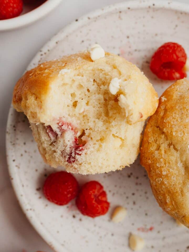 A muffin with a bite taken out of it on a small plate.