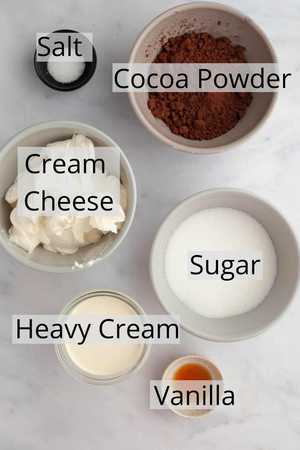 All the ingredients needed to make chocolate cream cheese frosting weighed out into small bowls.