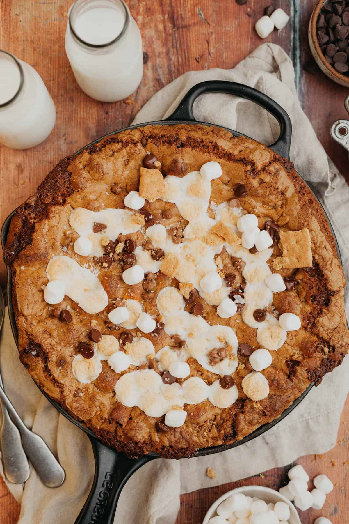 A marshmallow chocolate chip cookie skillet in a cast iron pan on a wooden surface.