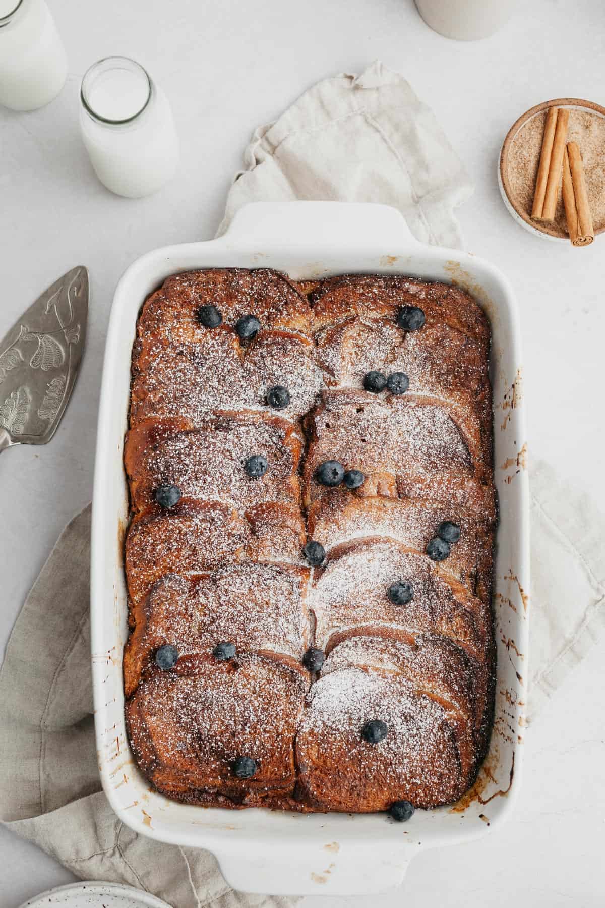 Baked french toast topped with blueberries and maple syrup.