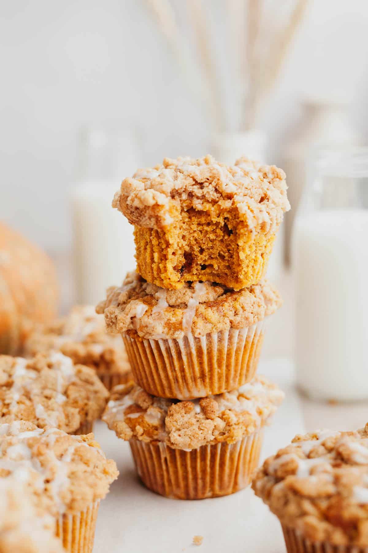 A stack of three pumpkin muffins with a streusel topping.