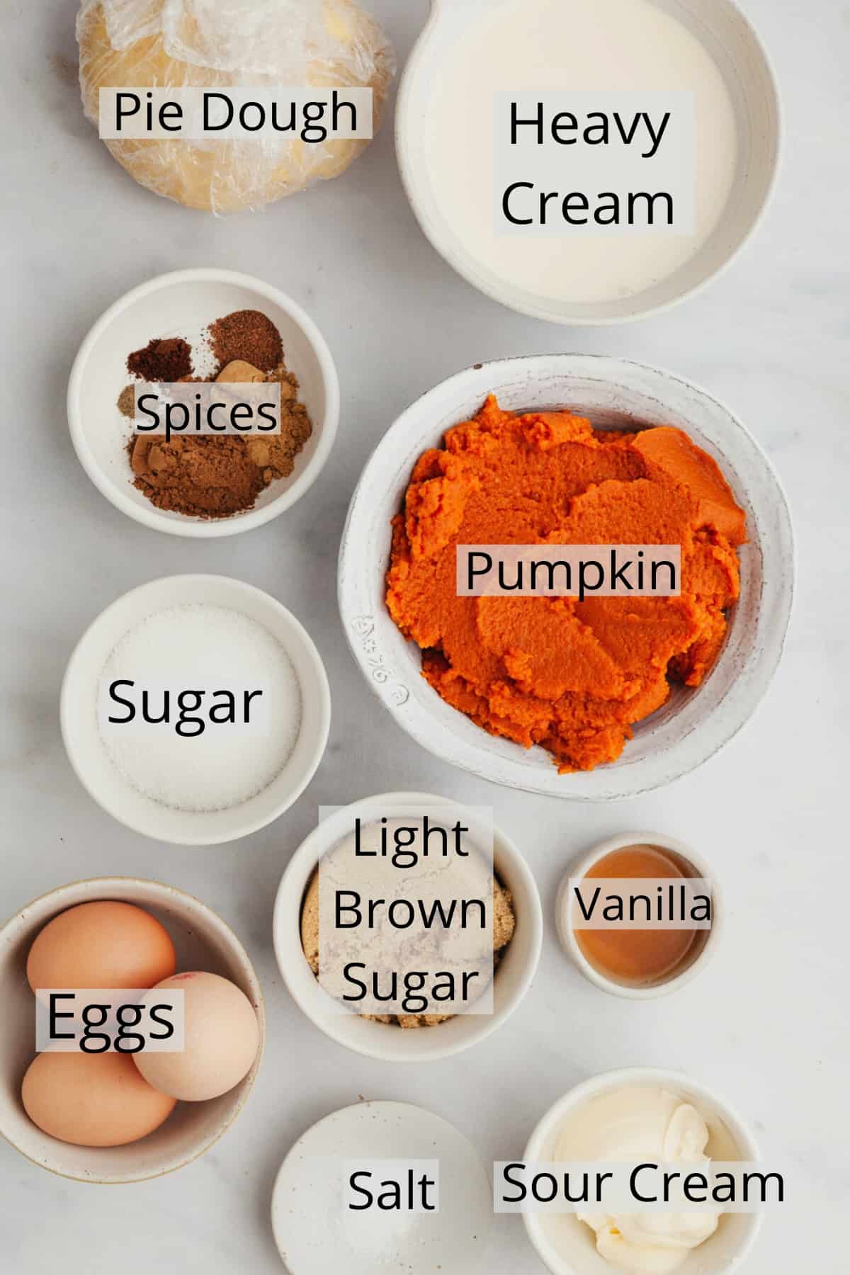 All the ingredients needed to make a pumpkin pie, weighed out into small bowls.