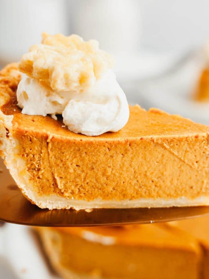 A slice of pumpkin pie on a pie server.