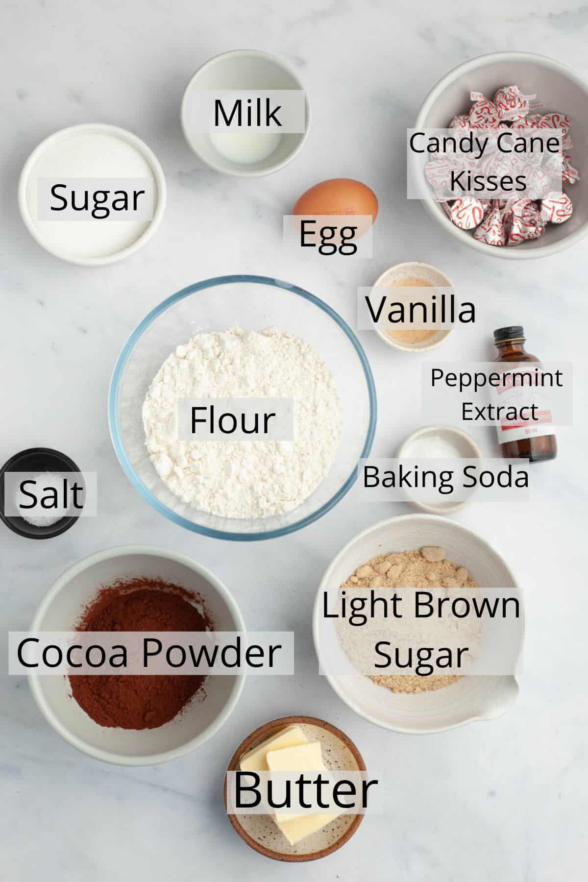 All the ingredients needed to make chocolate peppermint kiss cookies weighed out into small bowls.