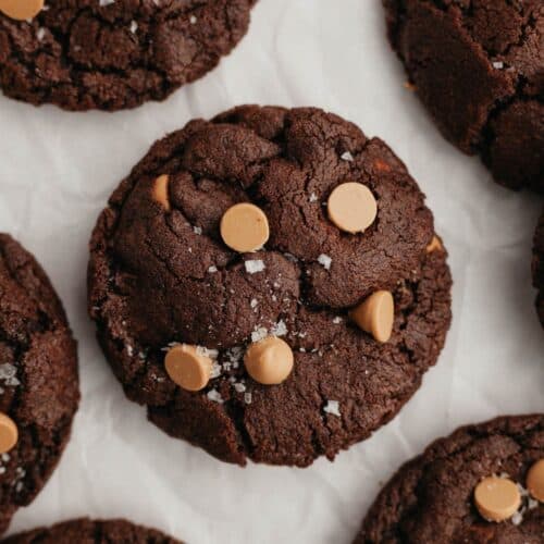A close up of a chocolate caramel cookie on parchment paper.
