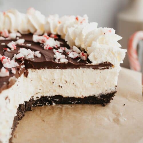 A close up of a peppermint bark cheesecake which has been cut, showing the inside of the cheesecake.