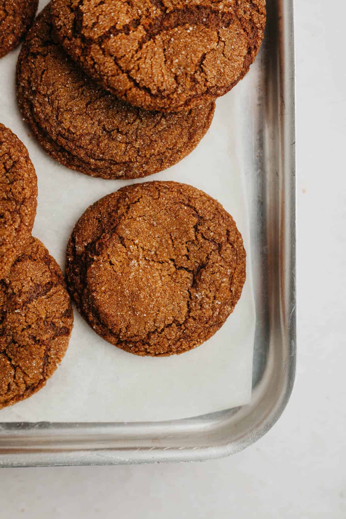A baking sheet with molasses cookies on it.
