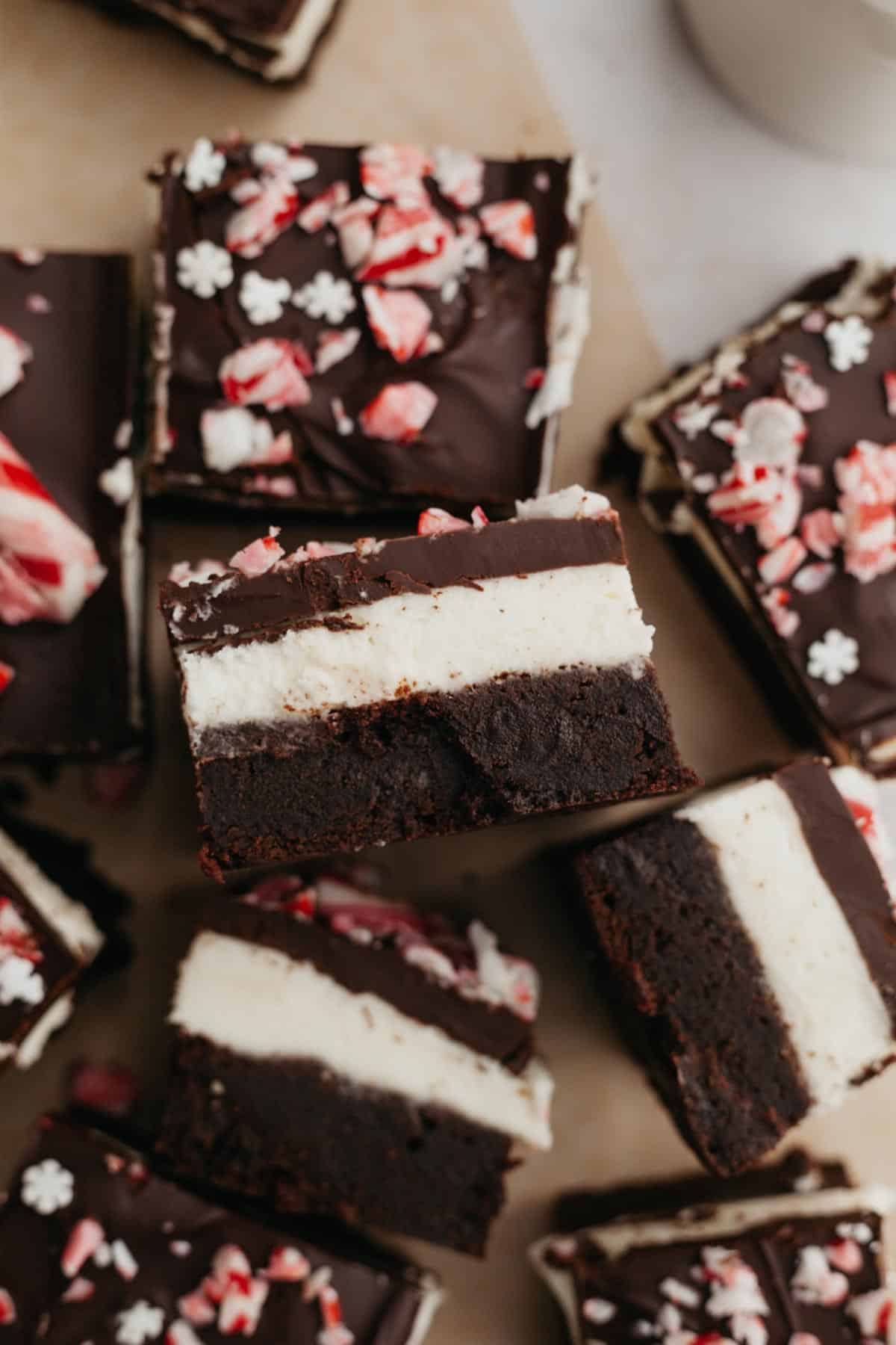 Layered peppermint brownies on parchment paper.