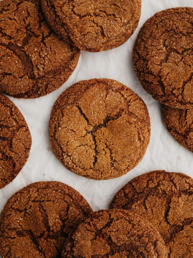 Ginger molasses crinkle cookies on parchment paper.