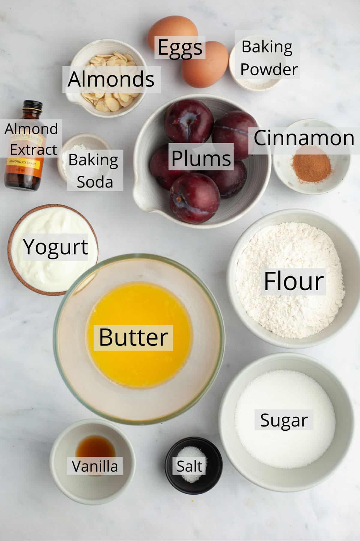All the ingredients needed to make yogurt plum cake weighed out into small bowls.