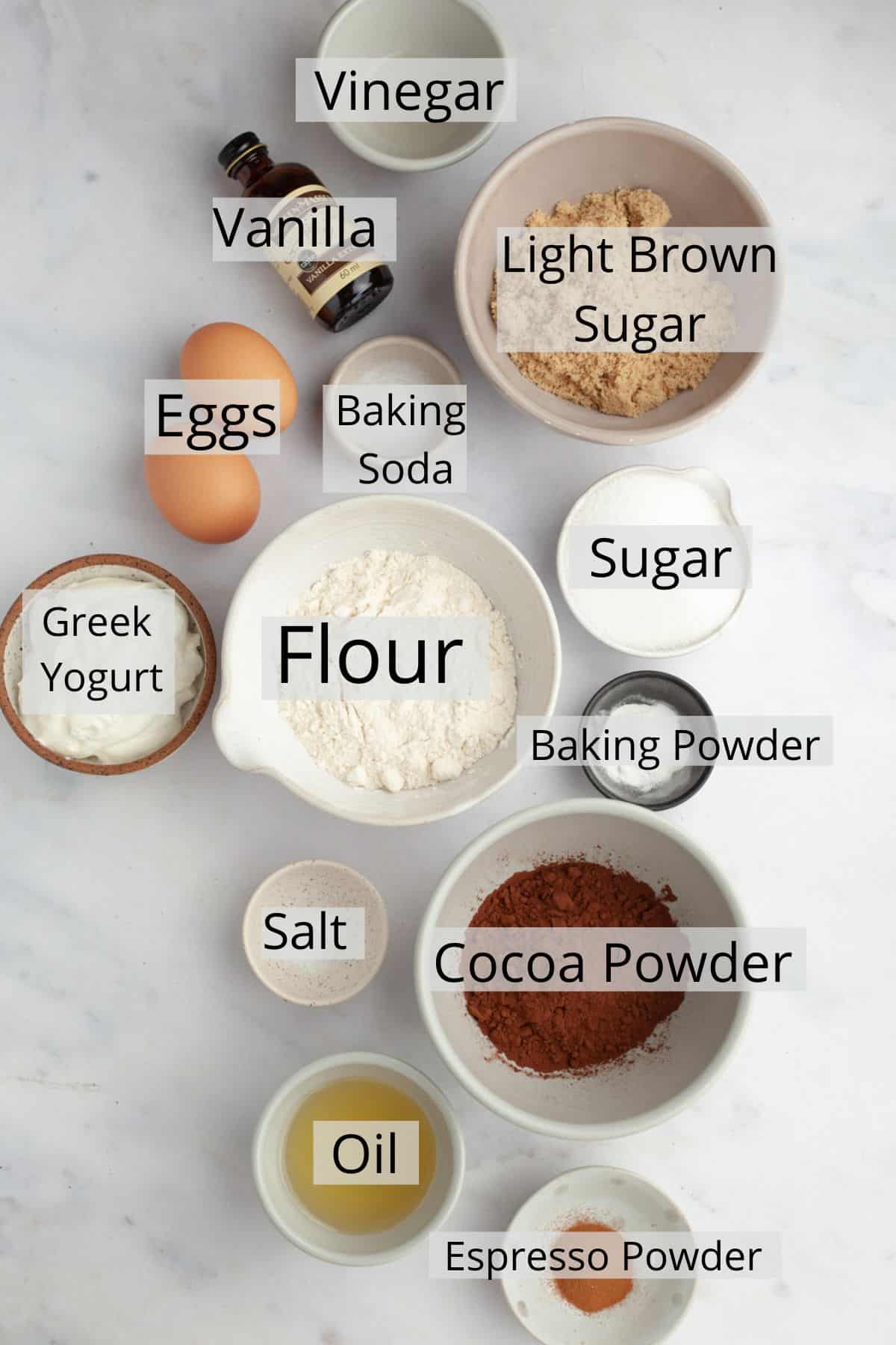 Ingredients needed to make chocolate cupcakes weighed out into small bowls.