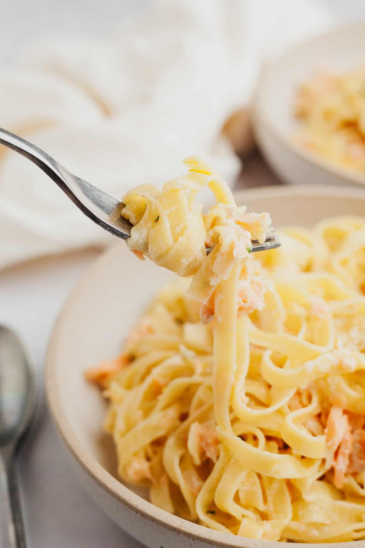 A close up of a fork pulling up pasta.