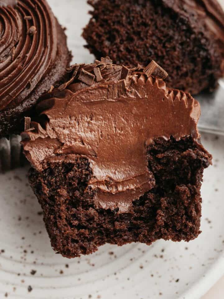 A chocolate cupcake sliced in half, showing a chocolate filling.