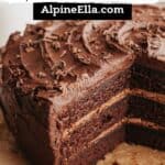A triple chocolate layer cake on parchment paper, several slices have been taken out.