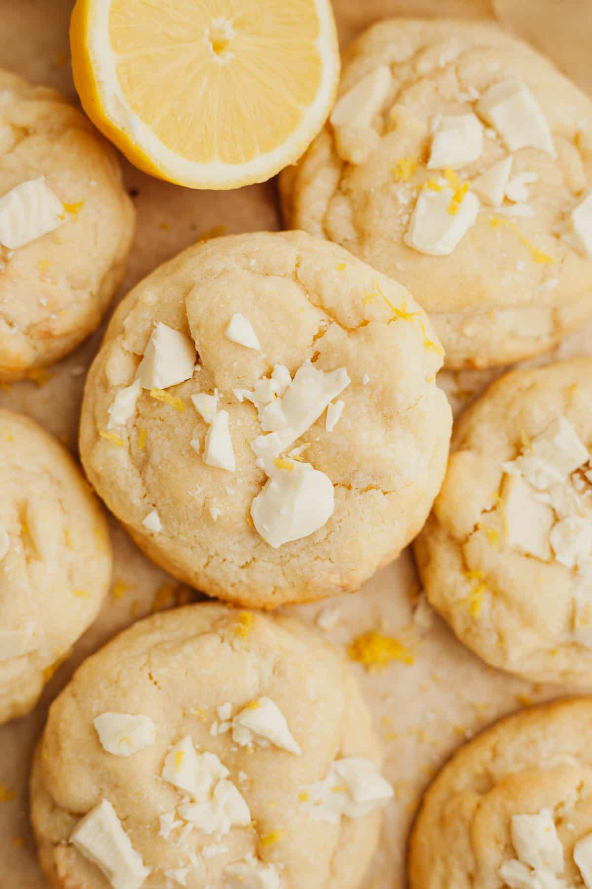 Lemon white chocolate cookies on light brown parchment paper.