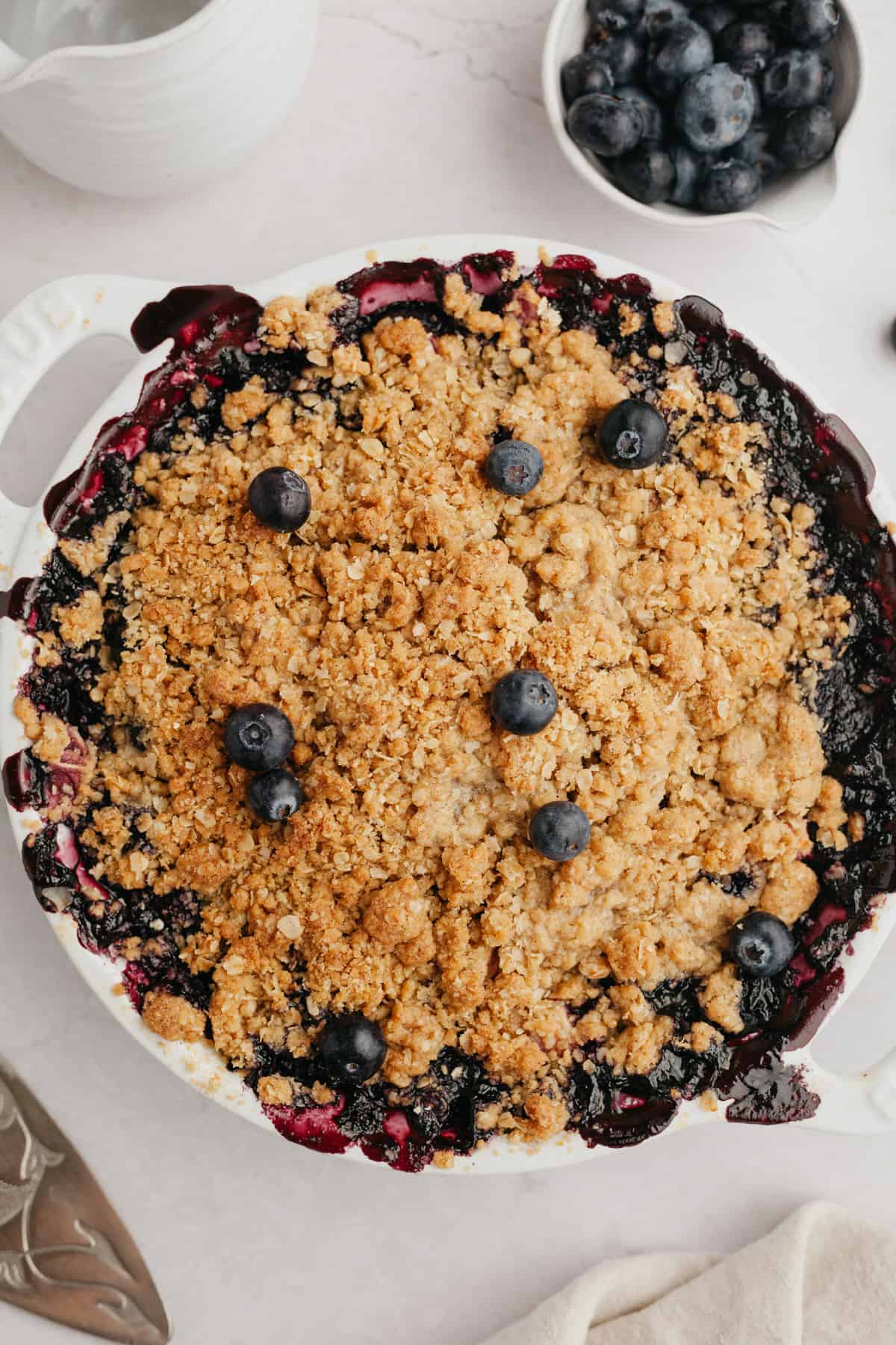 A blueberry and apple crumble in a white baking dish.