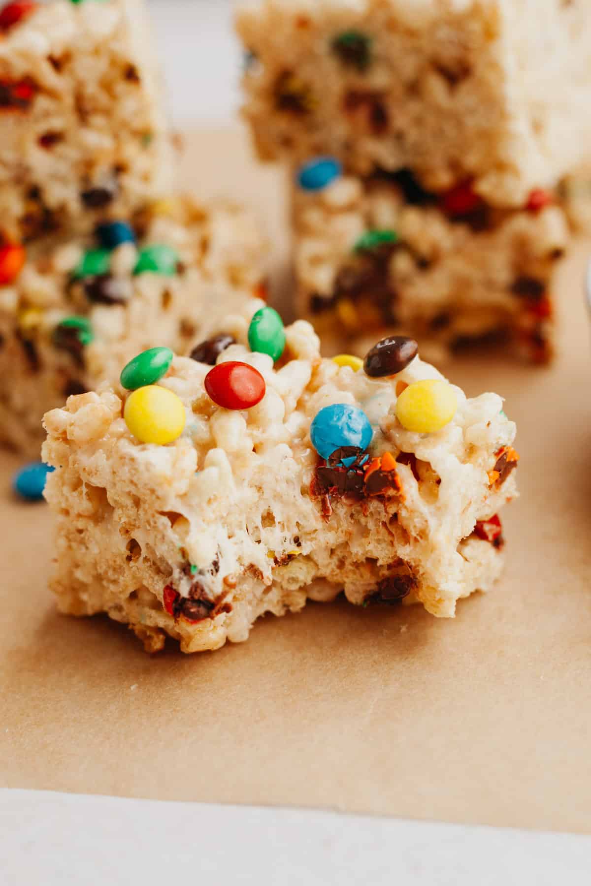 A close up of an m&m rice krispie treat with a bite taken out of it.