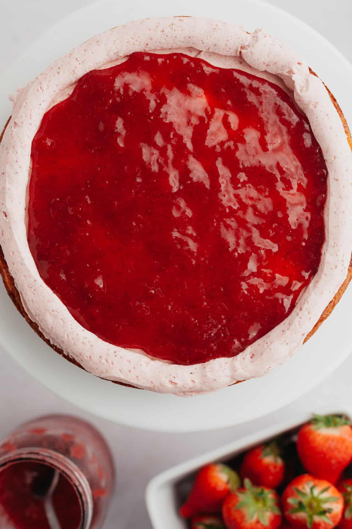 A cake layer covered in strawberry sauce.