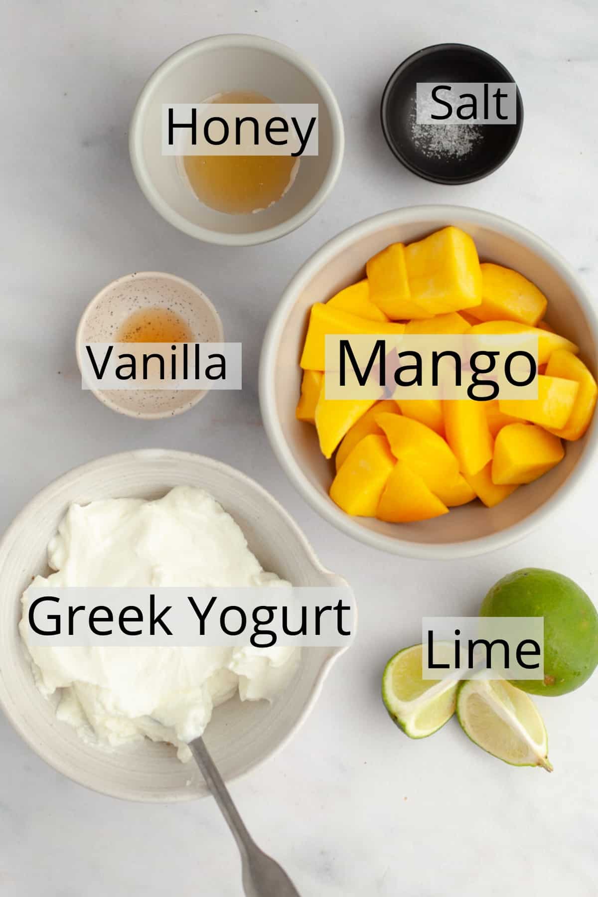 All the ingredients needed to make mango popsicles weighed out into small bowls.