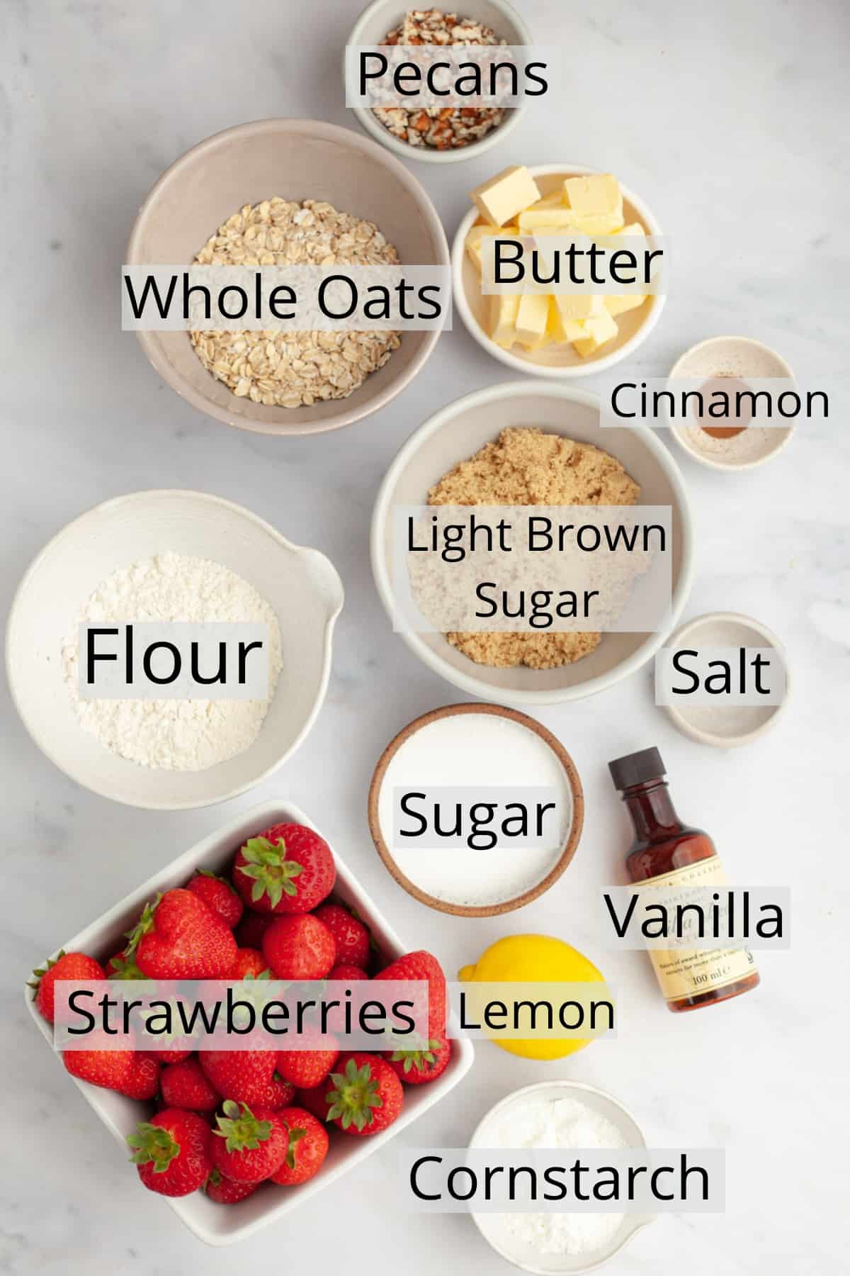 all the ingredients needed to make strawberry crisp weighed out into small bowls.
