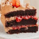 A slice of chocolate cake with strawberry filling and chocolate frosting.