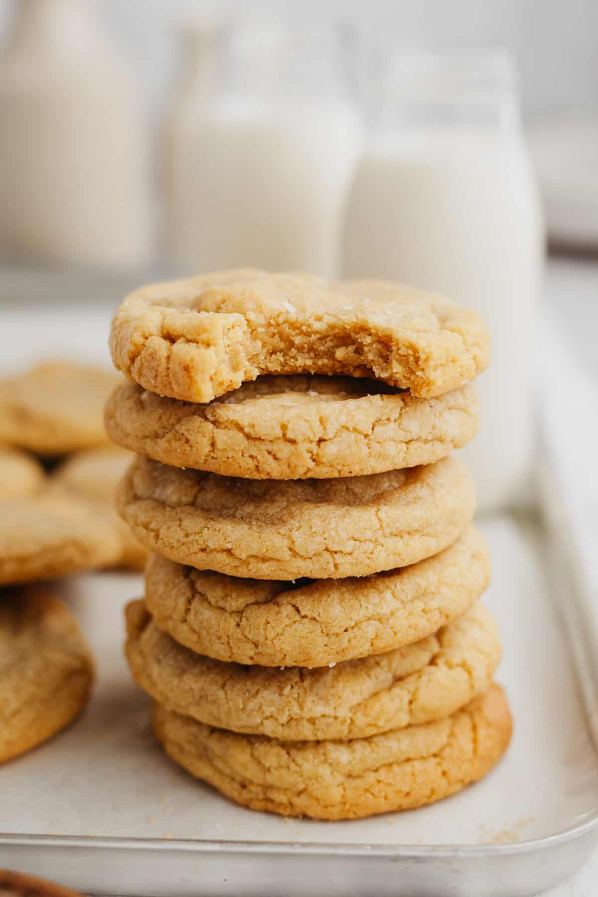 A stack of beige cookies on a baking sheet.