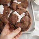 A hand holding a chocolate marshmallow cookie.