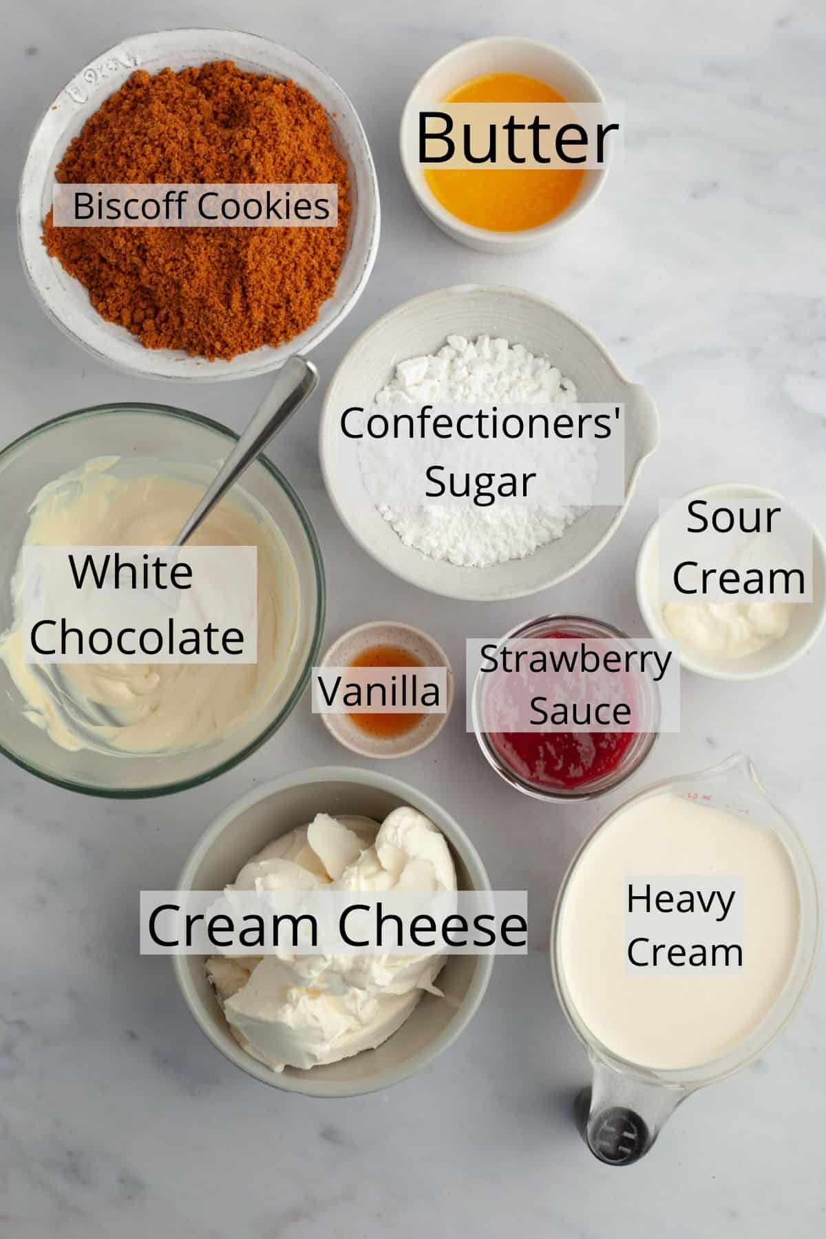 All the ingredients needed to make strawberry white chocolate cheesecake, weighed out into small bowls.