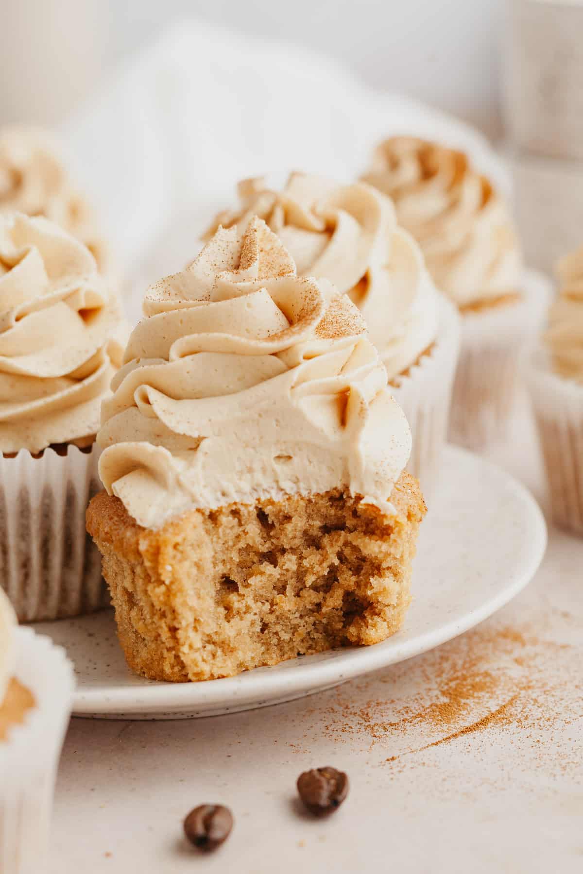 A close up of a coffee cupcake with a bite taken out of it.