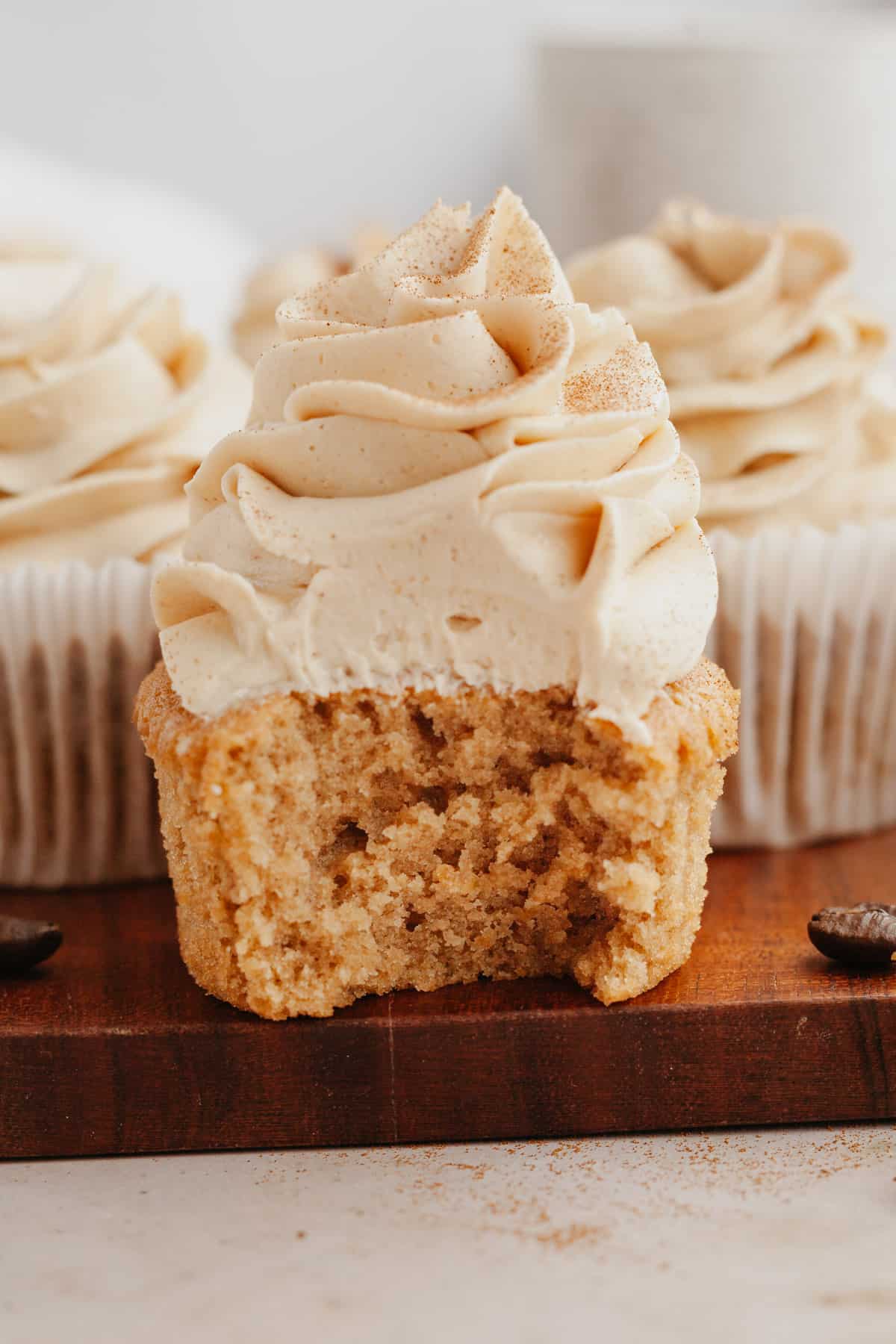 A close up of an espresso cupcake with a bite taken out of it.