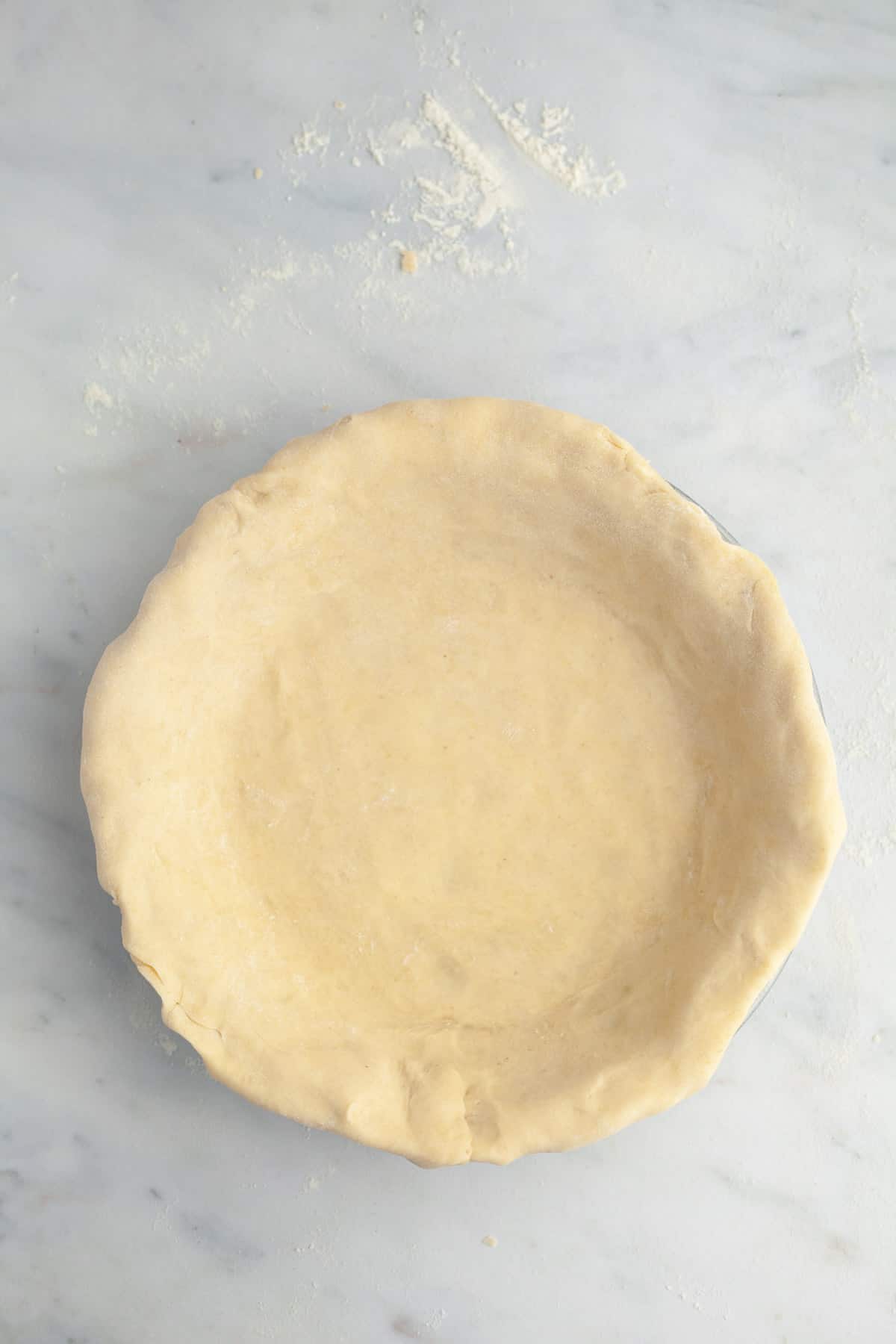 Unbaked pie dough in a pie plate.