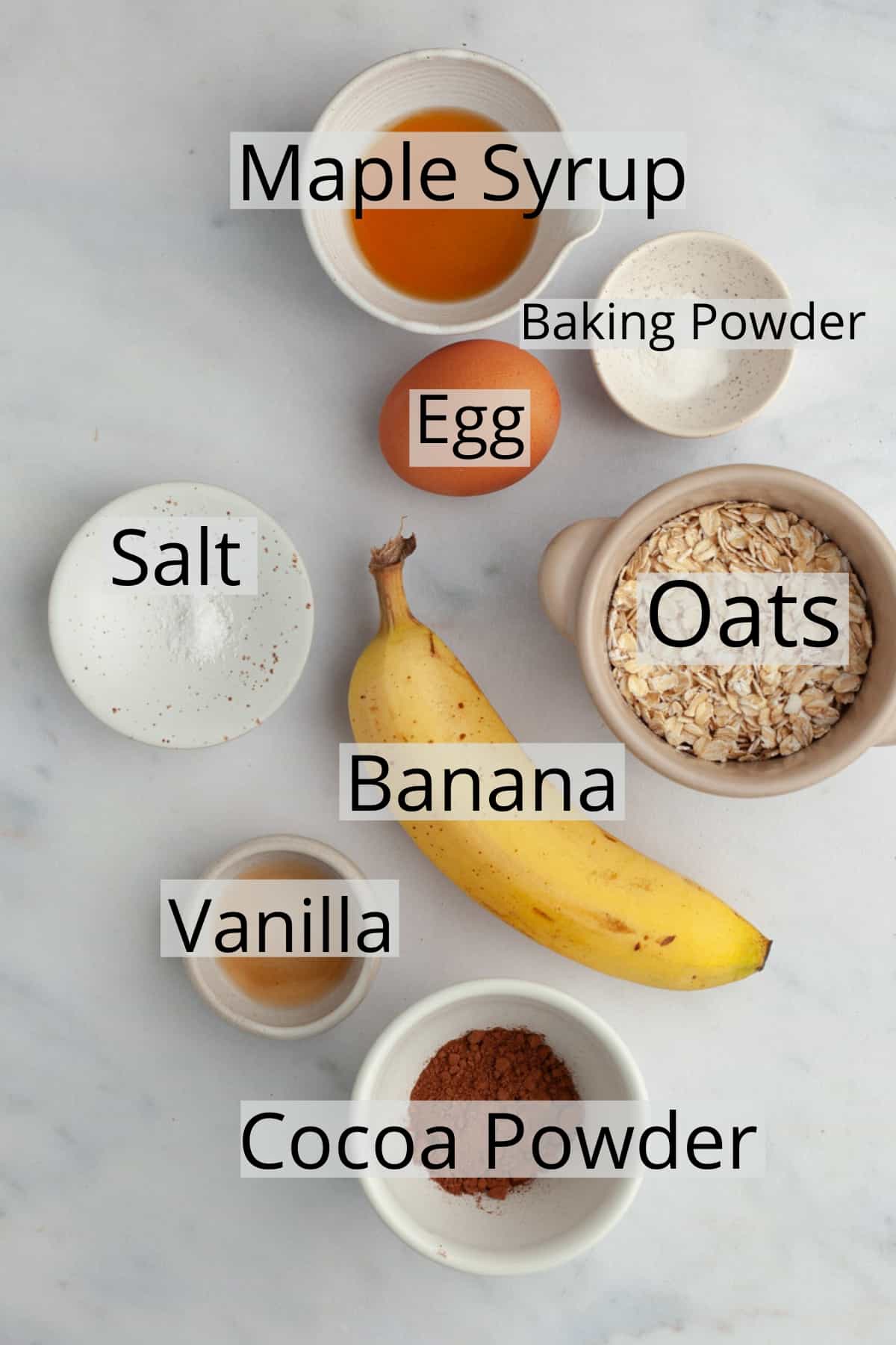 All the ingredients needed to make chocolate baked oatmeal, weighed out into small bowls.