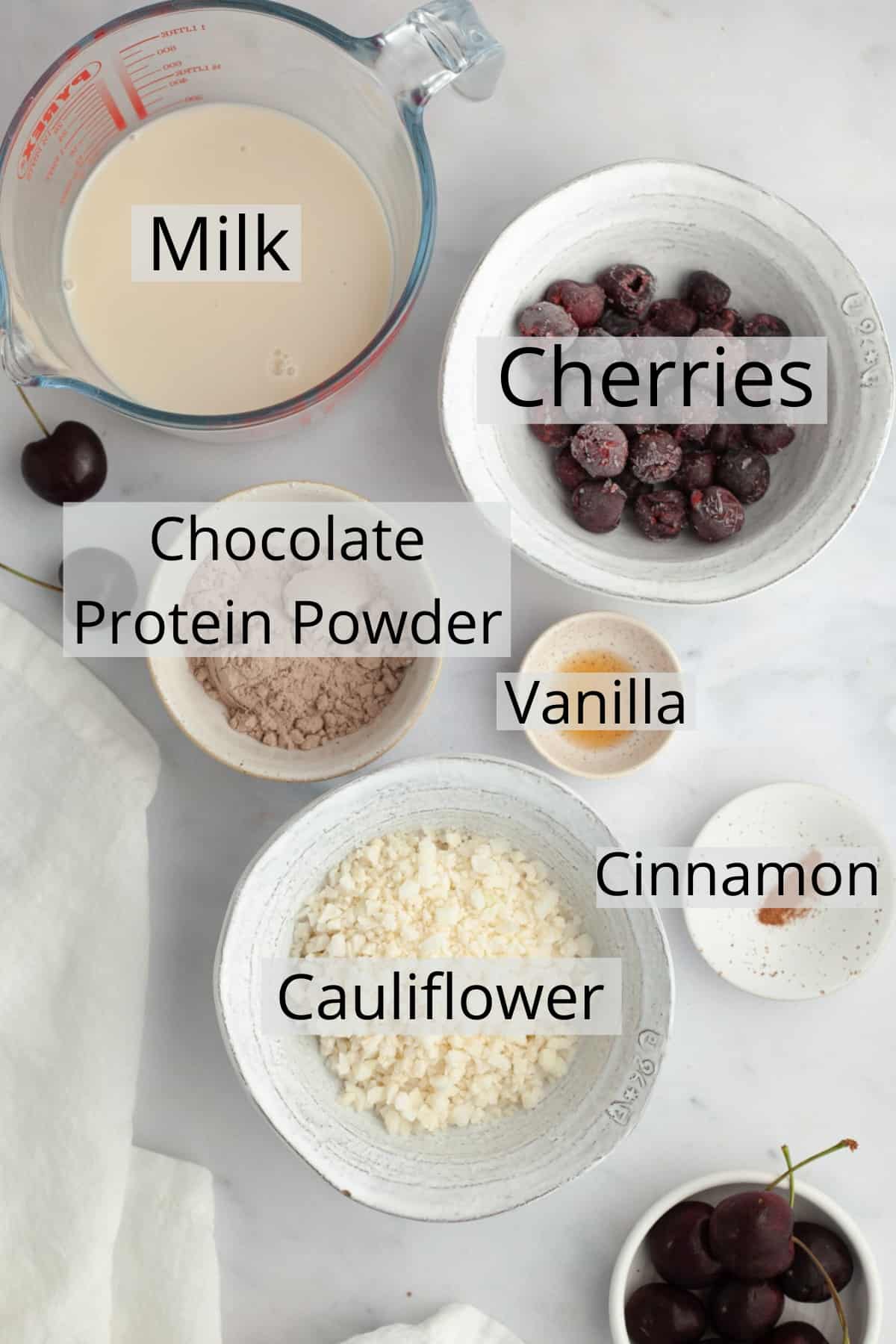 All the ingredients needed to make a chocolate cherry smoothie, weighed out into a small bowl.