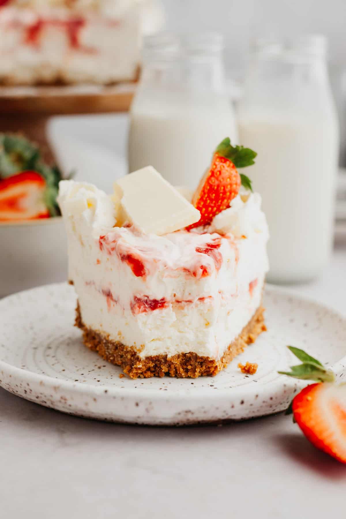 A white chocolate strawberry cheesecake on a plate.