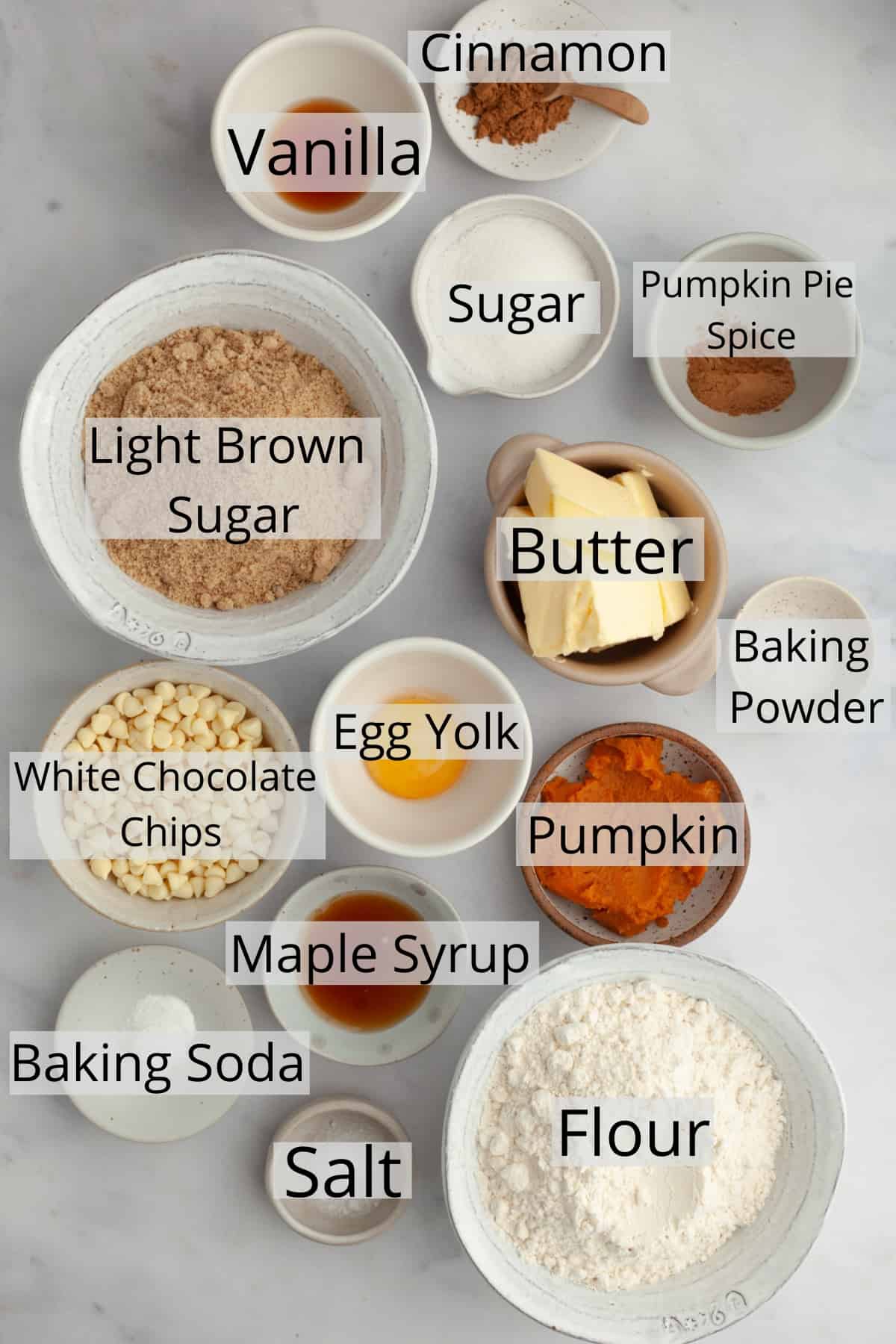 All the ingredients needed to make pumpkin cookies, weighed out into small bowls.