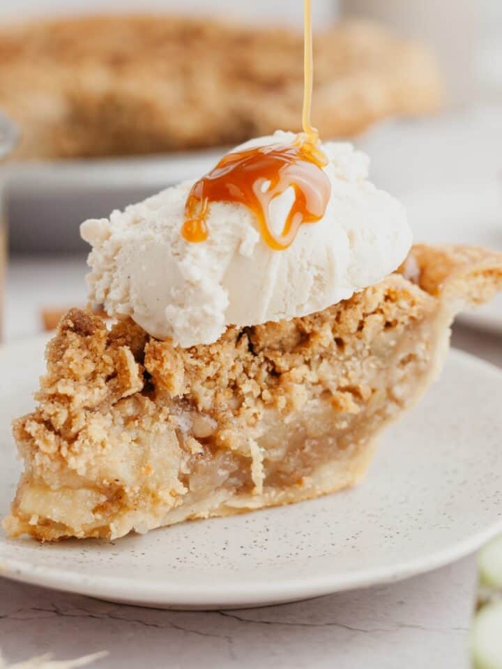 A slice of apple pie with a big scoop of vanilla ice cream on top.