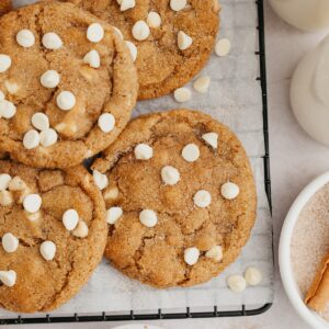Pumpkin cookies with white chocolate chips on parchment paper.
