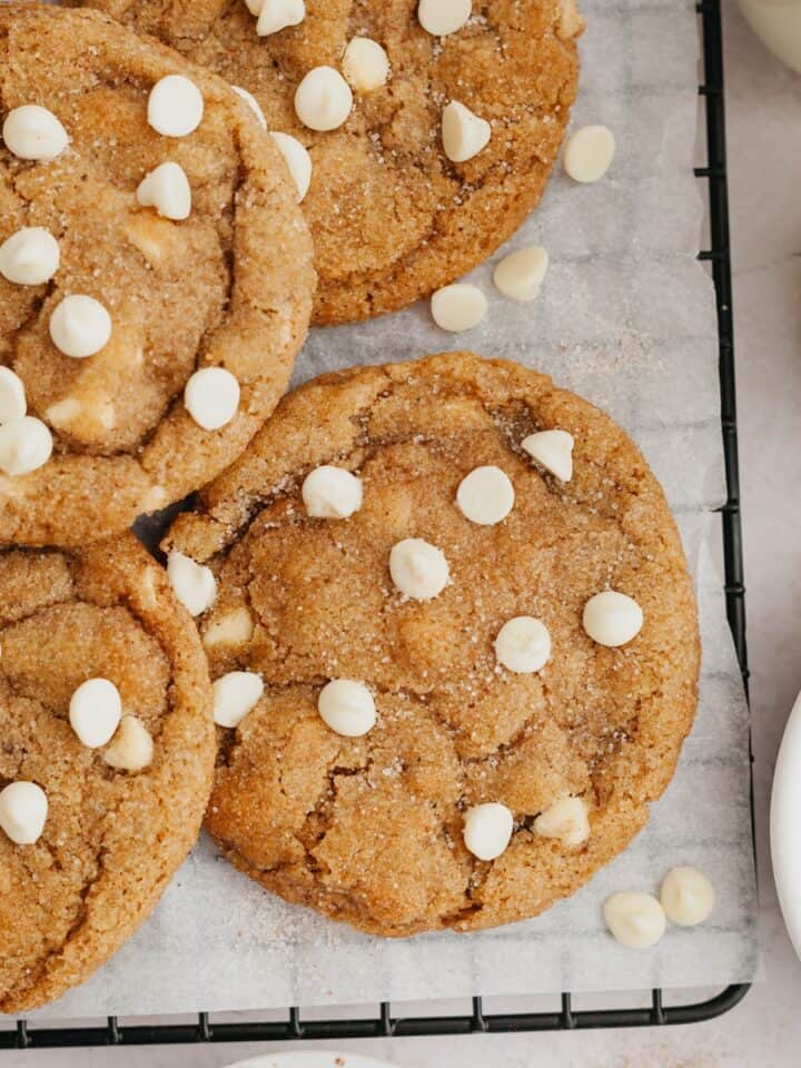 Pumpkin cookies with white chocolate chips on parchment paper.