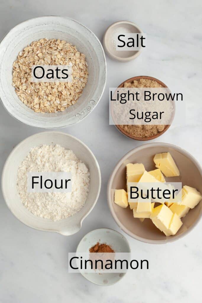 All the ingredients to make an oat crumble topping, weighed out into small bowls.